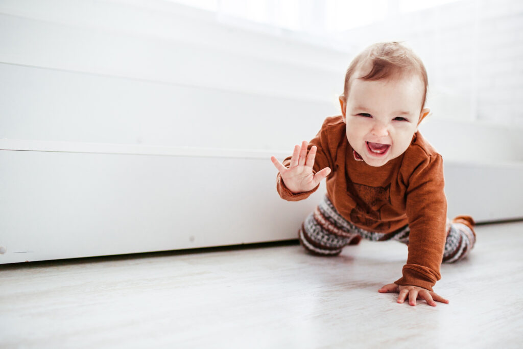 Baby Yoga: The Benefits and How to Get Started 61 happy child orange sweater plays with feather floor