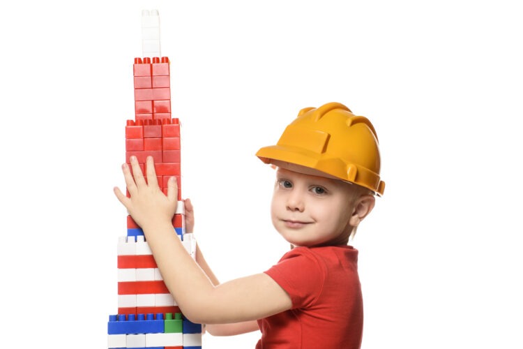 Baby Yoga: The Benefits and How to Get Started 60 little blond boy construction helmet red shirt standing near tower built from parts designer portrait isolate white background