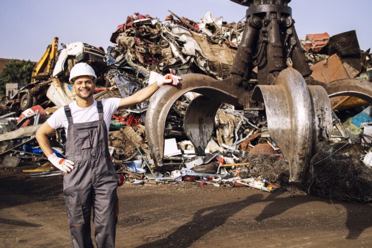 Closing the Loop: The Impact of the Circular Economy on the Scrap Business 52 Optimized worker standing by hydraulic industrial machine used lifting scrap metal parts junk yard