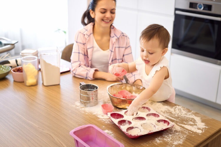 A Taste of Growing Up: Tips for Introducing Solid Foods to Your Baby 54 mother little baby girl preparing dough kitchen bake cookies happy time together