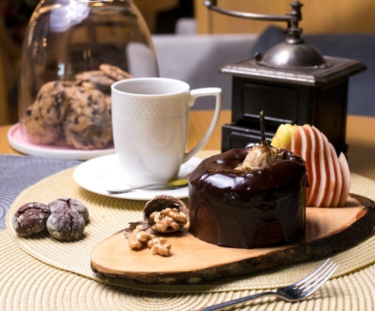 pear cake wooden board with walnuts chocolate fresh fruits tea side view