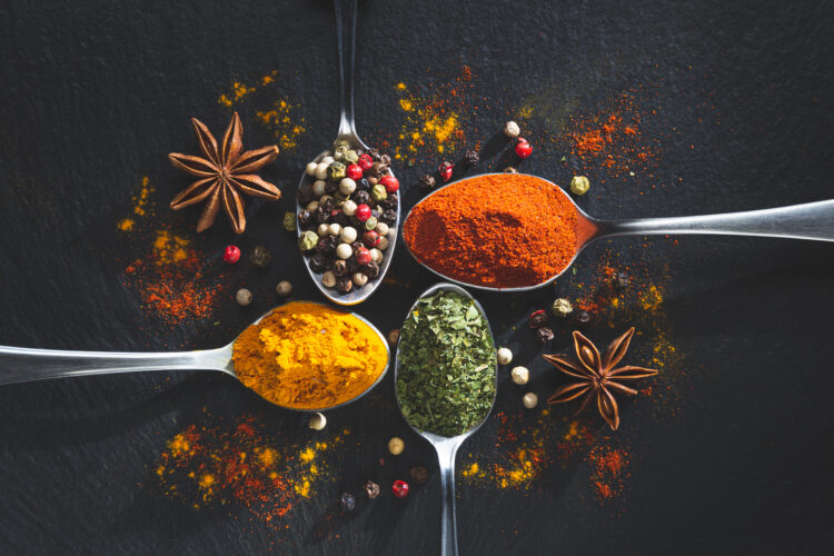 spoons with pepper paprika parsley turmeric black background
