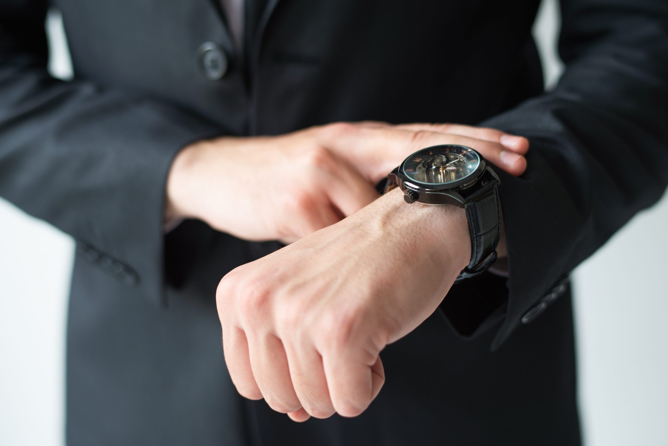 businessman consulting wristwatch scaled